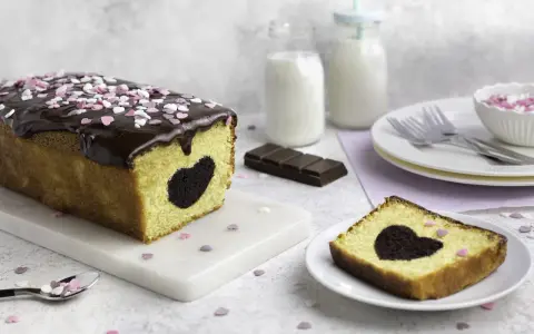 Herzförmiger Schokoladenkuchen mit Schokoladenglasur und Streuseln. Perfekt für Valentinstag Rezepte!