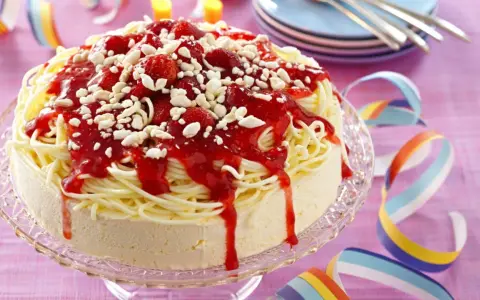 Ein lustiger Spaghetti-Eis-Kuchen mit Erdbeersoße und weißen Schokostückchen. Perfekt für jede Party!