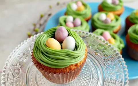 Oster-Cupcakes mit grünem Frosting als Nest und bunten Schokoladen-Eiern.
