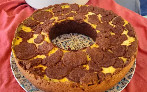 Ein köstlicher russischer Zupfkuchen mit einem Mürbeteigboden und einer cremigen Käsemasse, bedeckt mit schokoladigen Zupfen.