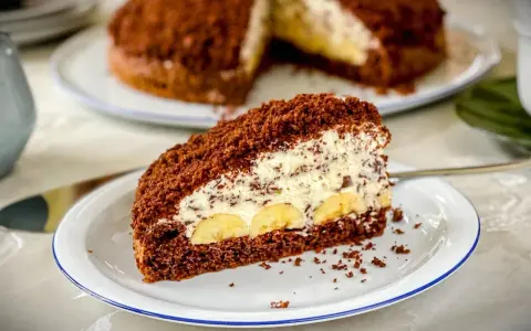 Ein Stück saftiger Maulwurfkuchen mit Bananen und Sahne. Dieses Maulwurfkuchen Rezept ist ein Genuss!