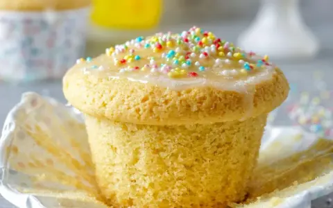 Ein Fanta Muffin mit Zuckerguss und bunten Streuseln, bereit zum Genießen.