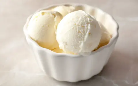 Schüssel mit cremigen Kugeln frozen joghurt, perfekt für einen heißen Sommertag.