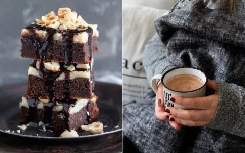 Gestapelte Cheesecake Brownies mit Schokoladenglasur und Nüssen, daneben eine Tasse Kakao.