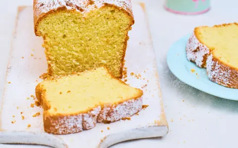 Ein saftiger Sandkuchen, bestäubt mit Puderzucker, wartet darauf, nach diesem einfachen Sandkuchen Rezept gebacken zu werden.