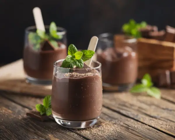 Schokoladenmousse im Glas, garniert mit Minze und Schokostückchen. Ein Genuss, der mit dem Thermomix leicht gelingt.