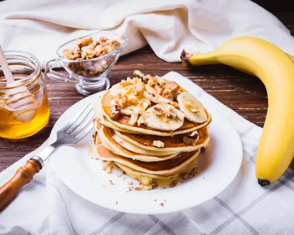 Leckeres protein pancakes rezept mit Bananen, Nüssen und Honig.