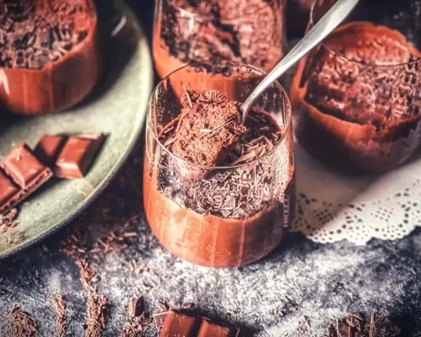 Lufterleichter Genuss: Mousse au chocolat ohne Ei, garniert mit Schokostreuseln. Ein Löffel zeigt die cremige Konsistenz.