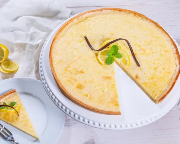 Ein Zitronentarte Rezept, das Lust auf mehr macht. Sonnengelbe Tarte mit frischen Zitronenscheiben und Minze.