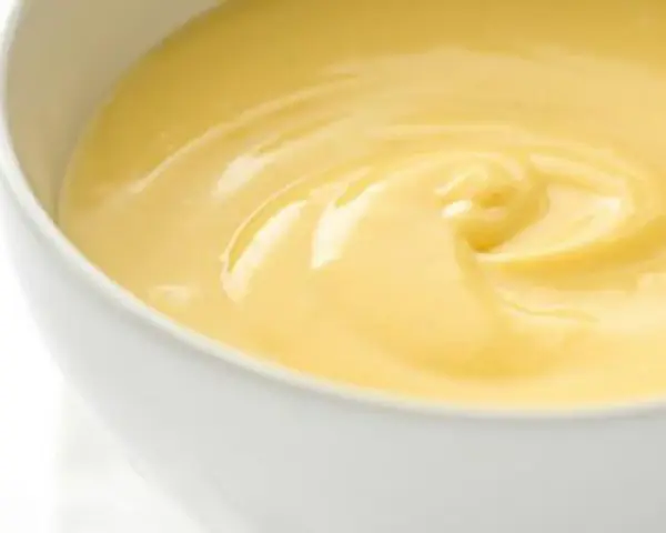 Cremige, gelbe Crema Pasticcera in einer weißen Schüssel, die zum Genuss einlädt.