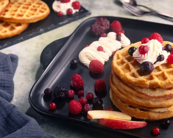 Leckere Apfelwaffeln mit frischen Beeren und Sahne. Ein tolles Rezept für süße Momente.