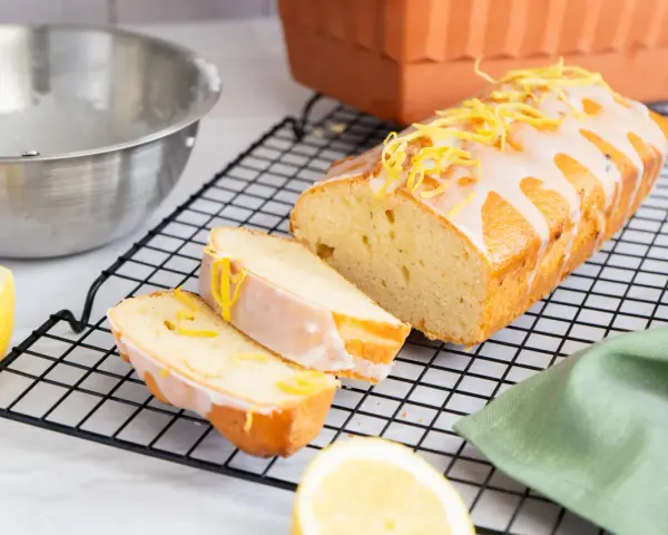 Ein saftiger Zitronenkuchen, frisch aus dem Ofen, mit Zuckerguss und Zitronenschale verziert. Perfekt für ein Zitronenkuchen Rezept.