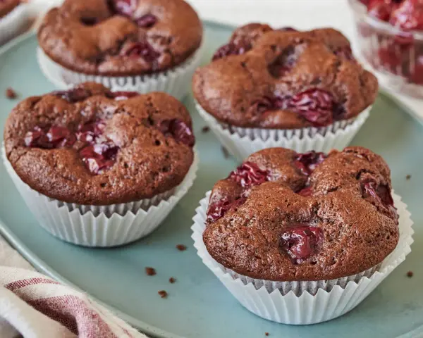 Saftige schoko kirsch muffins auf einem blauen Teller, bereit zum Genießen.