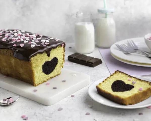 Herzförmiger Schokoladenkuchen mit Schokoladenglasur und Streuseln. Perfekt für Valentinstag Rezepte!