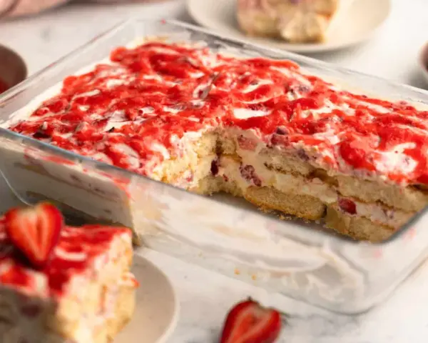 Ein saftiges Erdbeer Tiramisu in einer Glasform, geschichtet mit Löffelbiskuits, Creme und frischen Erdbeeren, verlockt zum Genuss.