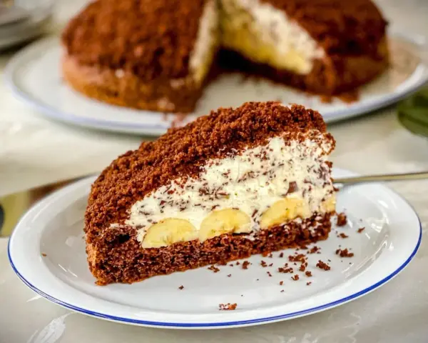 Ein Stück saftiger Maulwurfkuchen mit Bananen und Sahne. Dieses Maulwurfkuchen Rezept ist ein Genuss!