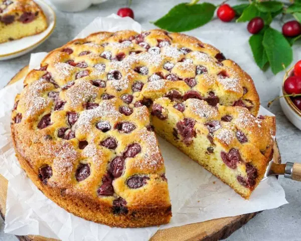 Saftiger Kirschkuchen, perfekt für ein Kirschkuchen Rezept. Mit Puderzucker bestäubt und voller Kirschen.