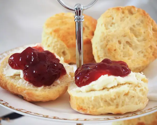 Zwei Scones mit Clotted Cream und Marmelade auf einer Etagere. Ein köstliches Rezept für Scones, perfekt für den Nachmittagstee.