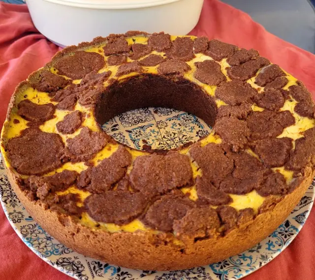 Ein köstlicher russischer Zupfkuchen mit einem Mürbeteigboden und einer cremigen Käsemasse, bedeckt mit schokoladigen Zupfen.