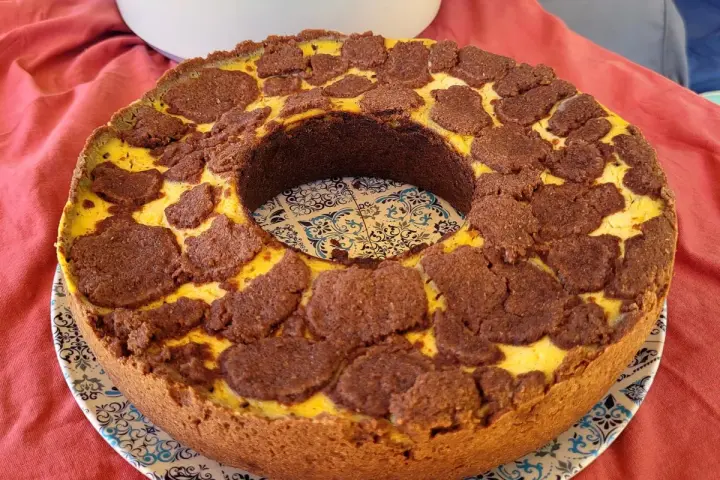Ein köstlicher russischer Zupfkuchen mit einem Mürbeteigboden und einer cremigen Käsemasse, bedeckt mit schokoladigen Zupfen.