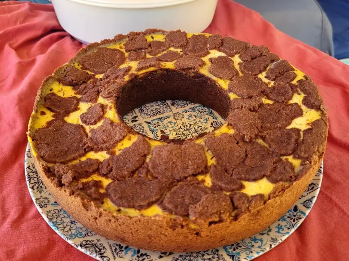 Ein köstlicher russischer Zupfkuchen mit einem Mürbeteigboden und einer cremigen Käsemasse, bedeckt mit schokoladigen Zupfen.