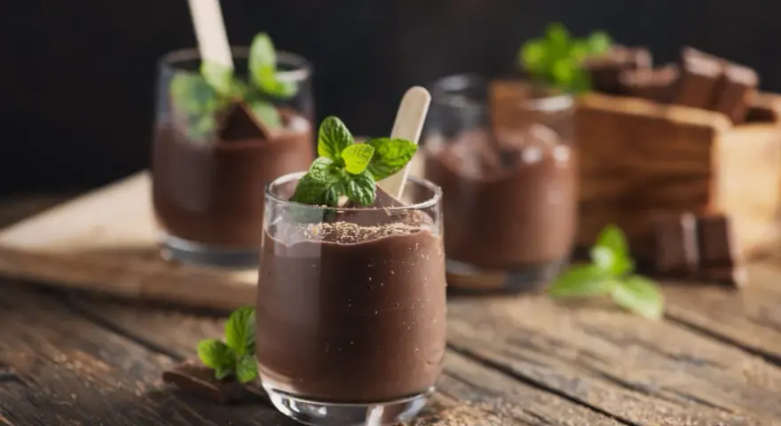 Schokoladenmousse im Glas, garniert mit Minze und Schokostückchen. Ein Genuss, der mit dem Thermomix leicht gelingt.