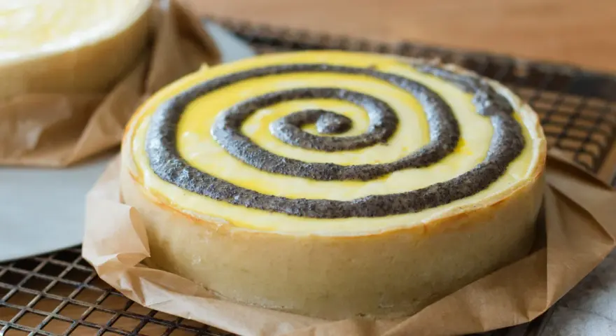 Ein köstlicher no bake cheesecake mit Mohn-Spiralen auf einem Gitter.
