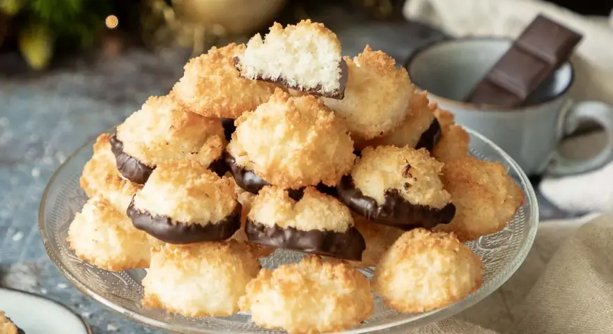 Ein Berg goldbrauner Kokosmakronen, die untere Hälfte in dunkle Schokolade getaucht. Perfekt für ein schnelles Kokosmakronen Rezept.
