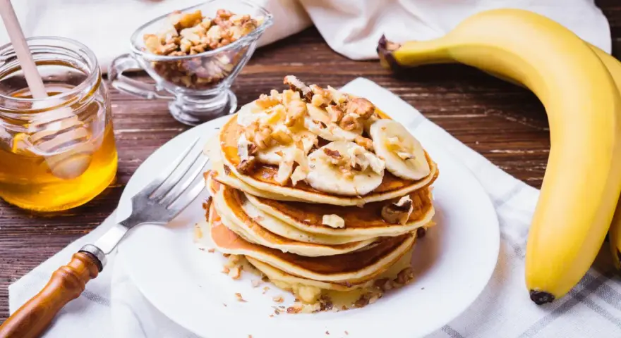 Leckeres protein pancakes rezept mit Bananen, Nüssen und Honig.