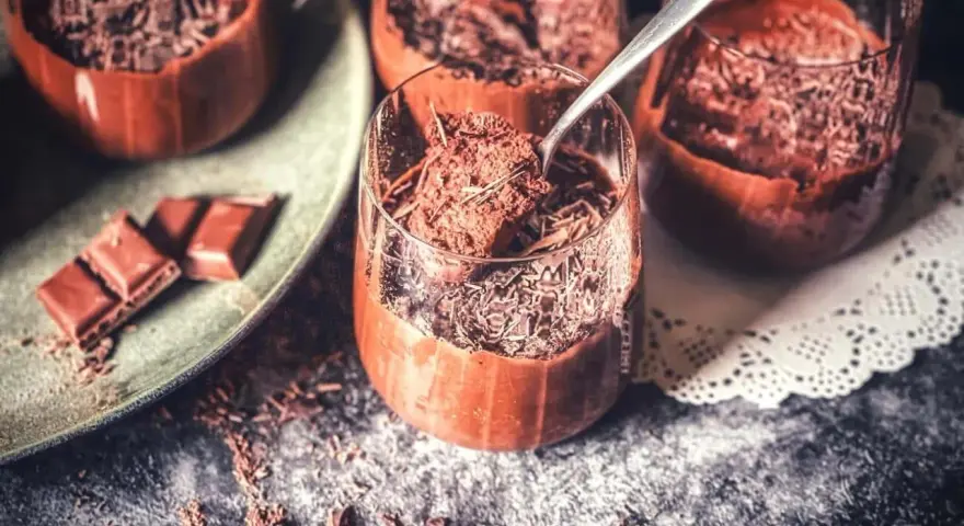 Lufterleichter Genuss: Mousse au chocolat ohne Ei, garniert mit Schokostreuseln. Ein Löffel zeigt die cremige Konsistenz.