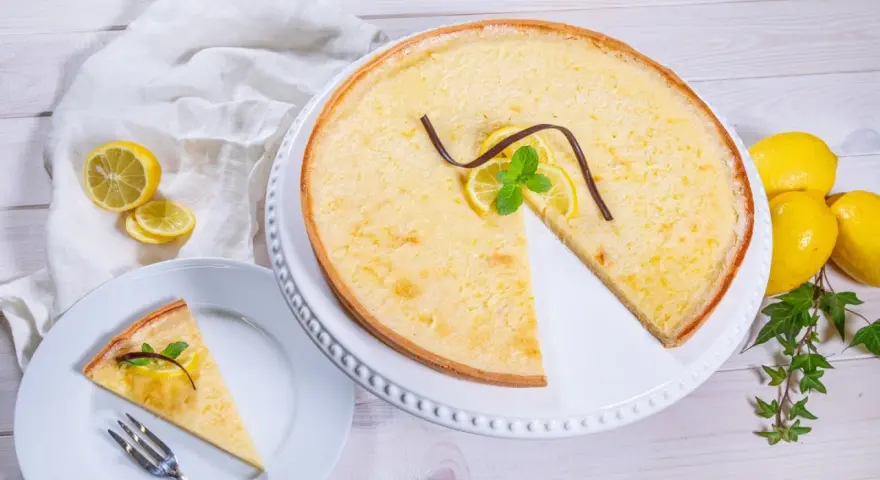 Ein Zitronentarte Rezept, das Lust auf mehr macht. Sonnengelbe Tarte mit frischen Zitronenscheiben und Minze.