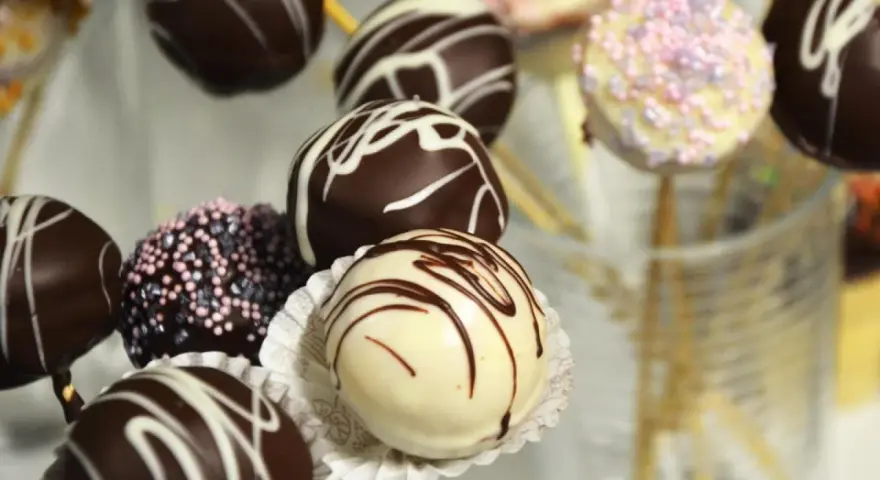 Bunte Kuchen am Stiel, dekoriert mit Schokolade und Streuseln, warten darauf, genascht zu werden.