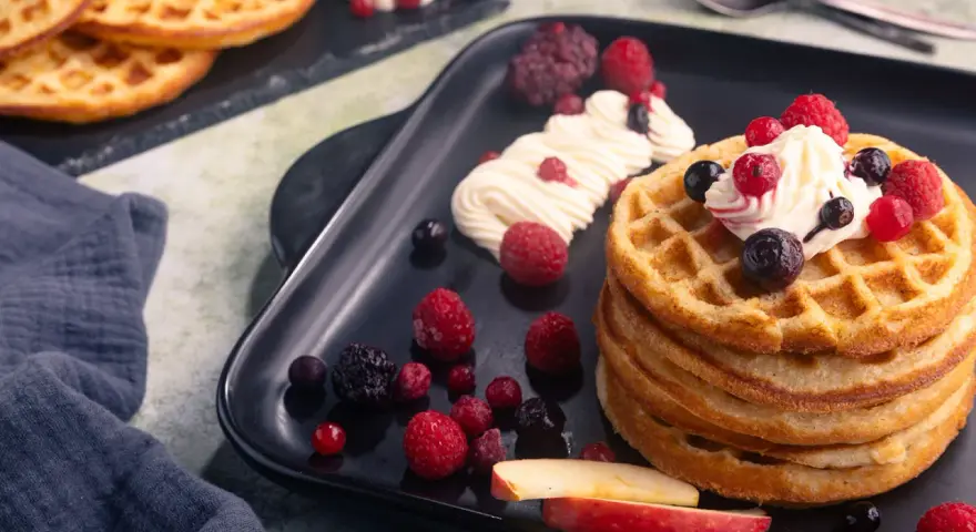 Leckere Apfelwaffeln mit frischen Beeren und Sahne. Ein tolles Rezept für süße Momente.