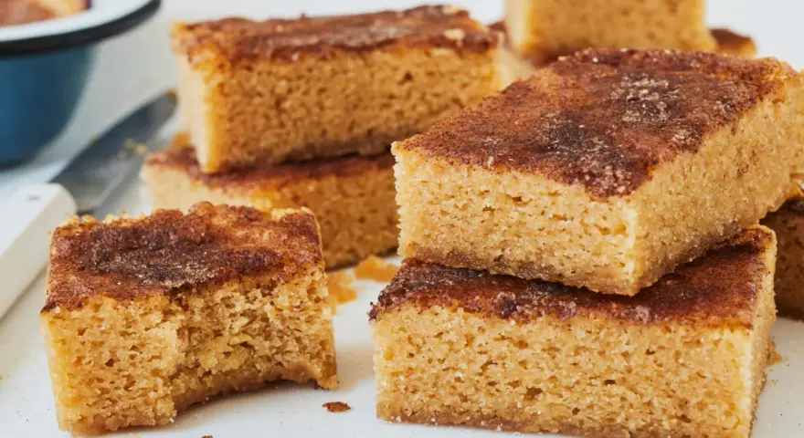 Saftige Blondies mit Zimt-Zucker-Decke, perfekt für dein Blondies Rezept. Ein Stück wurde bereits probiert!
