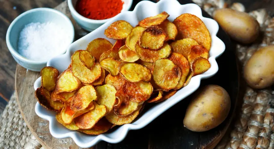 Selbstgemachte Kartoffelchips, goldbraun und knusprig, mit Salz und Paprikapulver gewürzt. So einfach ist kartoffelchips selber machen!