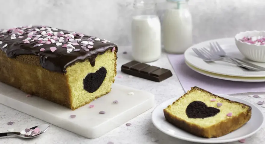 Herzförmiger Schokoladenkuchen mit Schokoladenglasur und Streuseln. Perfekt für Valentinstag Rezepte!
