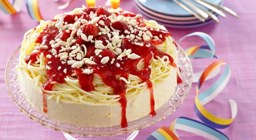 Ein lustiger Spaghetti-Eis-Kuchen mit Erdbeersoße und weißen Schokostückchen. Perfekt für jede Party!