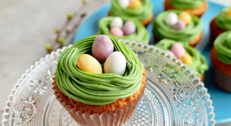 Oster-Cupcakes mit grünem Frosting als Nest und bunten Schokoladen-Eiern.