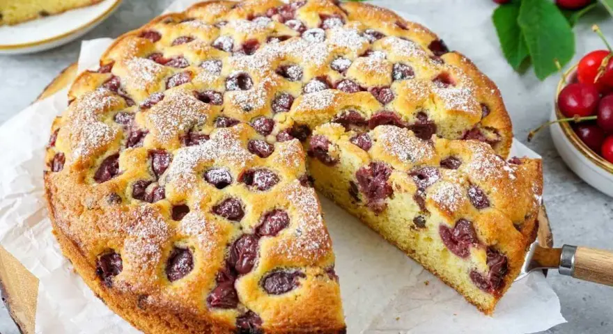 Saftiger Kirschkuchen, perfekt für ein Kirschkuchen Rezept. Mit Puderzucker bestäubt und voller Kirschen.