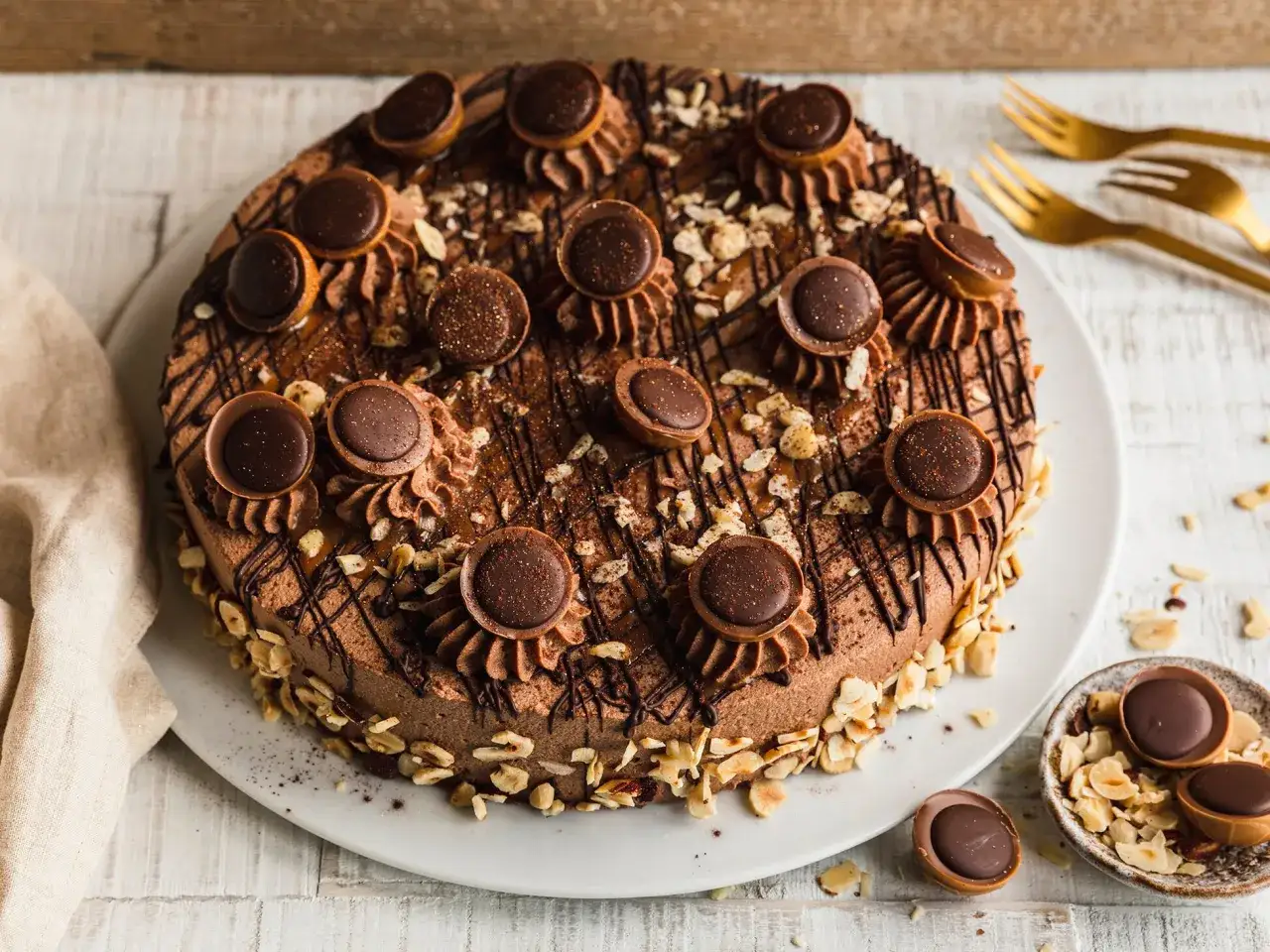 Eine köstliche Schokoladen-Toffifee Torte, verziert mit Toffifee-Pralinen, Schokostreuseln und gehackten Nüssen.