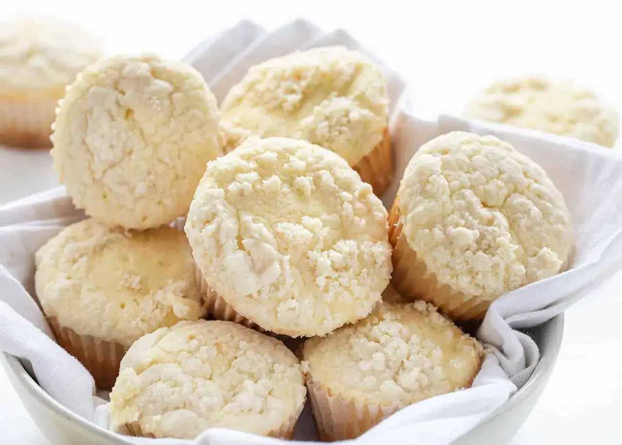 Korb voller cremiger cheesecake muffins mit Streuseln, perfekt f&uuml;r einen s&uuml;&szlig;en Genuss.