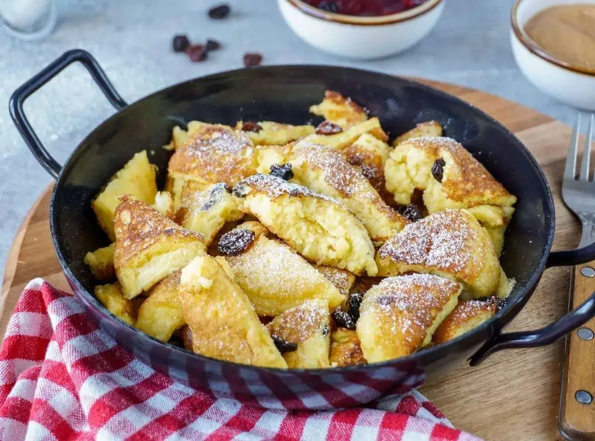 Kaiserschmarrn, fluffig und goldbraun, mit Rosinen und Puderzucker bestreut, zubereitet im Thermomix.