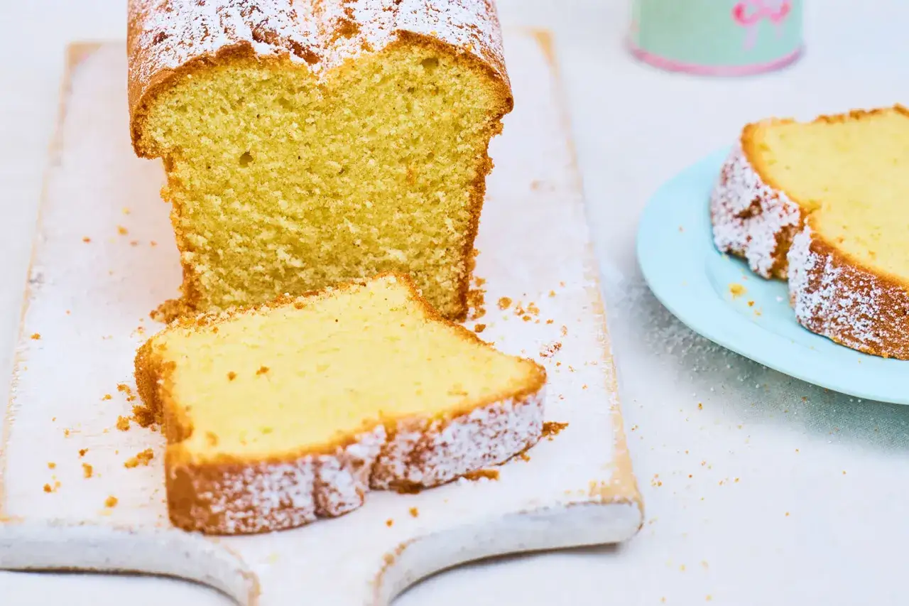 Ein saftiger Sandkuchen, bestäubt mit Puderzucker. Dieses einfache Sandkuchen Rezept ist perfekt für jeden Anlass.