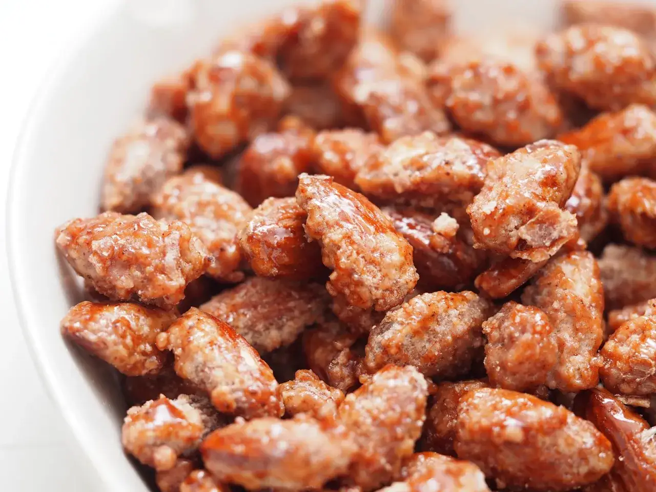 Nahaufnahme von gebrannten Mandeln in einer weißen Schüssel. Perfekt für ein gebrannte mandeln rezept.
