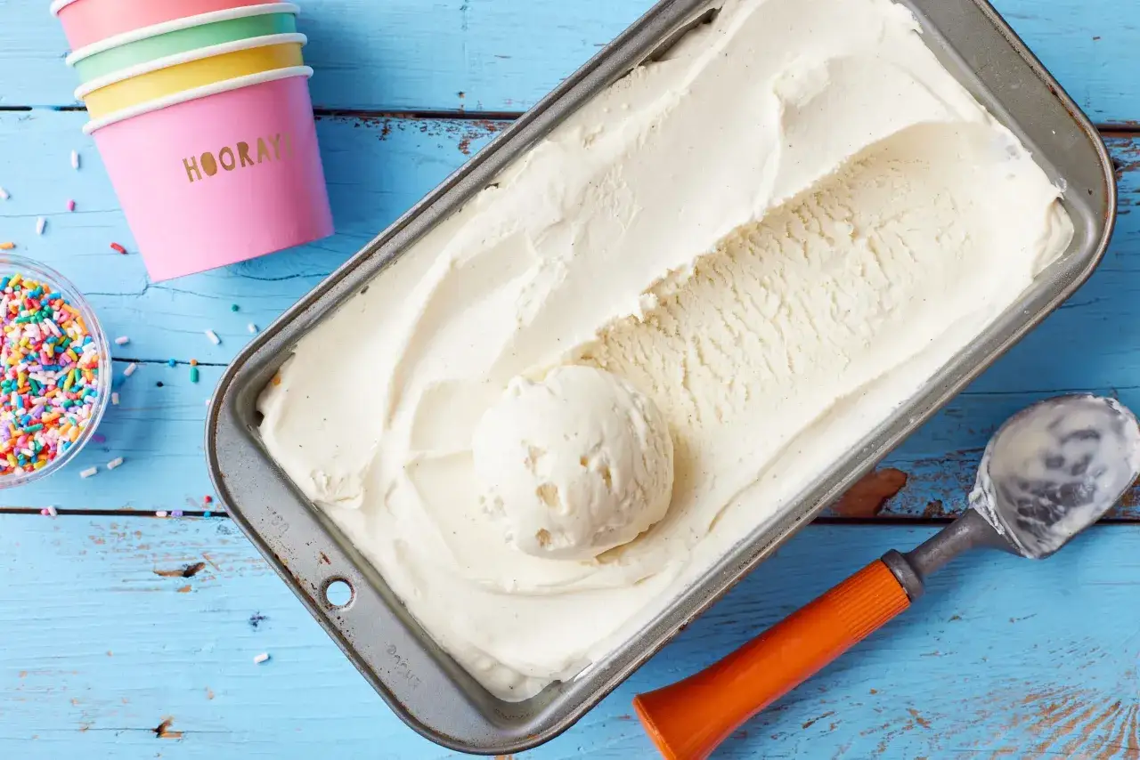 Vanilleeis selber machen ist ein Genuss! Cremiges Eis in einer Metallform, bunte Streusel und fr&ouml;hliche Becher warten auf den Genuss.