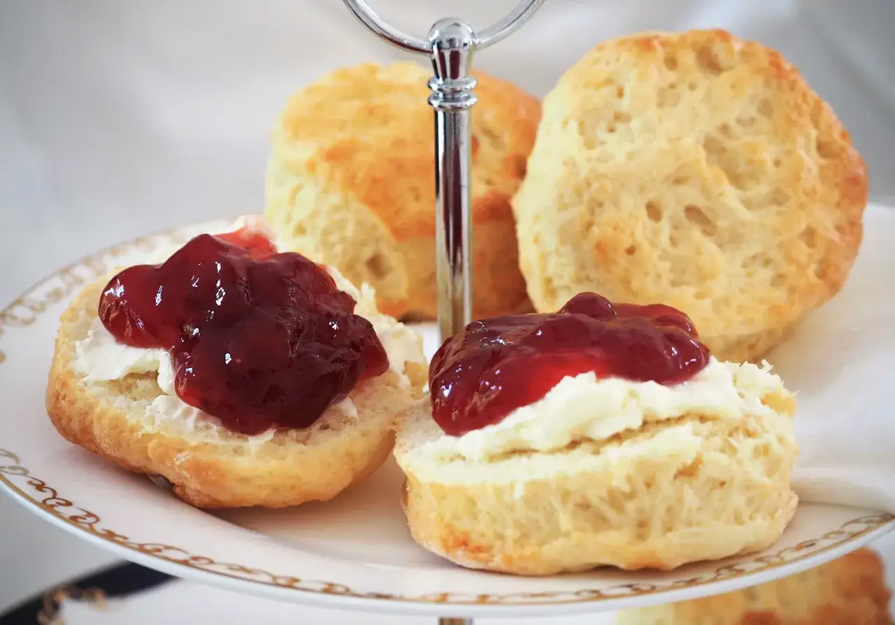 Zwei Scones mit Clotted Cream und Marmelade auf einer Etagere. Ein köstliches Scones Rezept für den Nachmittagstee.