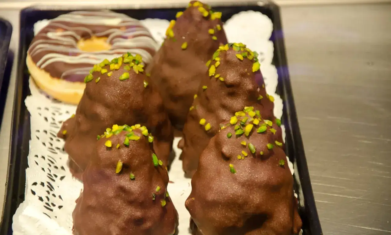 Schokoladenkegel mit Pistazien, wie ein Granatsplitter-Rezept, neben einem Schokodoner.