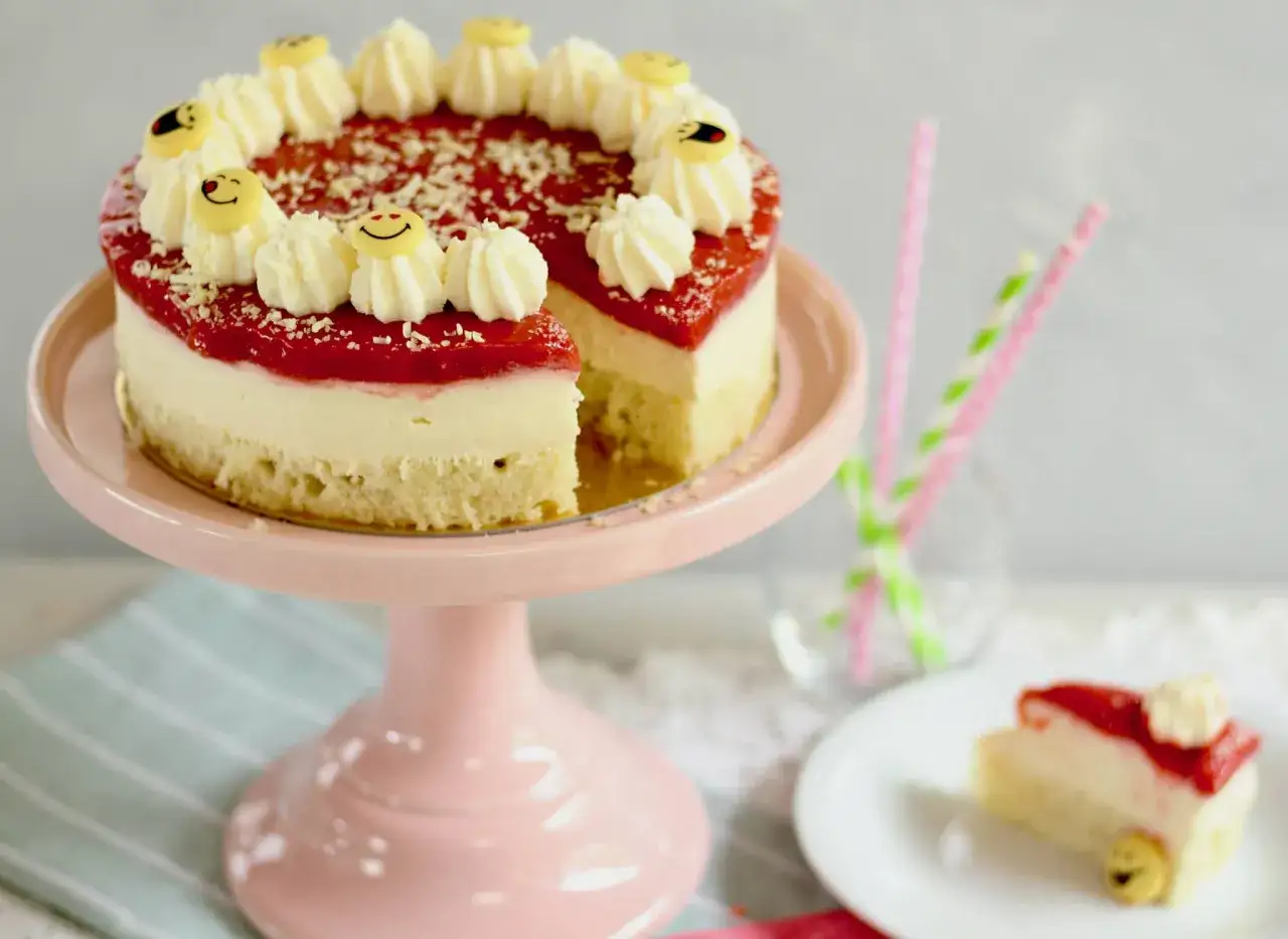 Ein k&ouml;stlicher Kuchen, der wie Spaghetti-Eis aussieht, mit Erdbeer-Topping und lustigen Smiley-Dekorationen.
