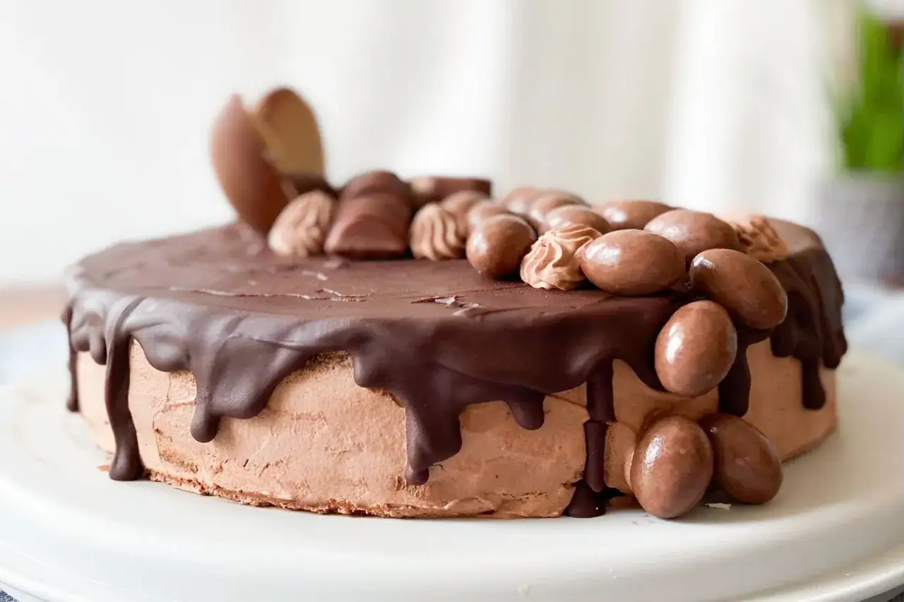 Eine köstliche Nutella Torte mit Schokoladenglasur und vielen Schoko-Eiern und -Riegeln verziert.