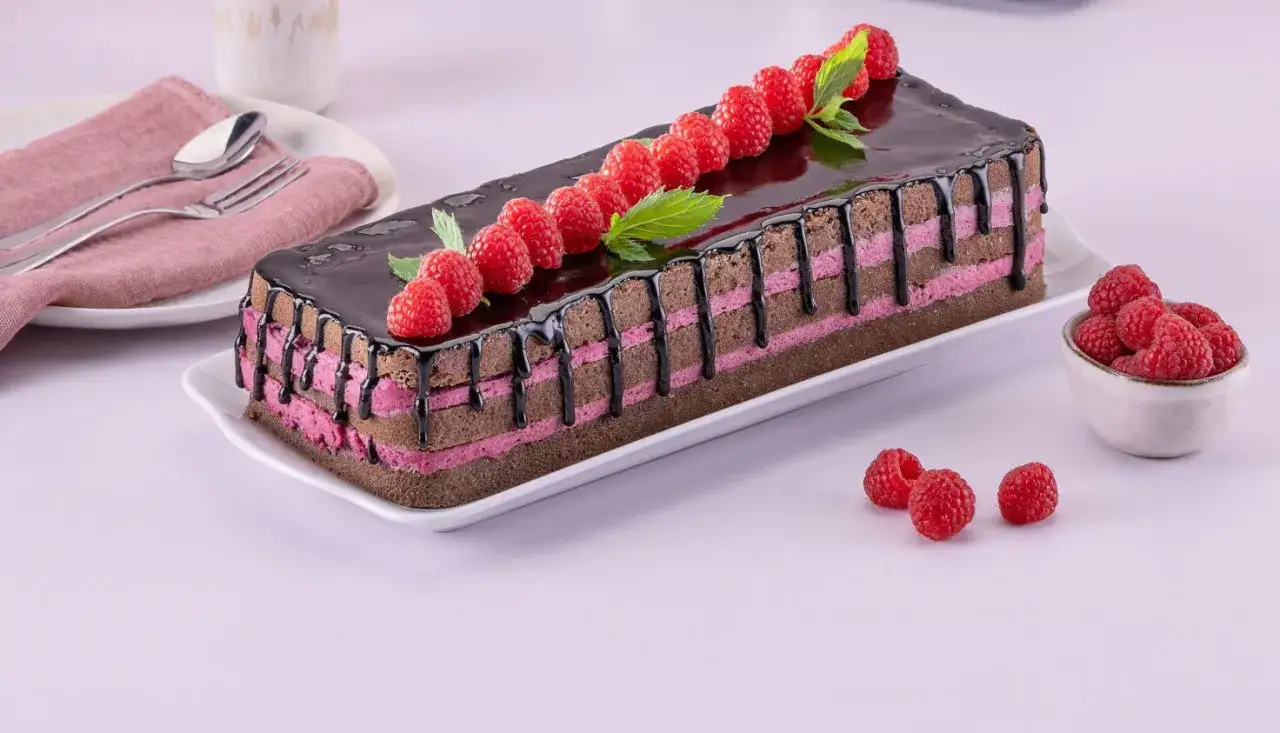 Schoko Himbeer Torte mit gl&auml;nzendem Schokoladenguss, Himbeeren und Minze verziert.